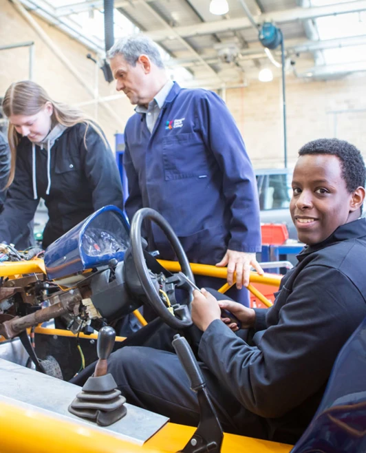 Instructor and students collaborating on an engine repair project, focusing on mechanical details in a hands-on learning session. Instructor and students collaborating on an engine repair project, focusing on mechanical details in a hands-on learning session.